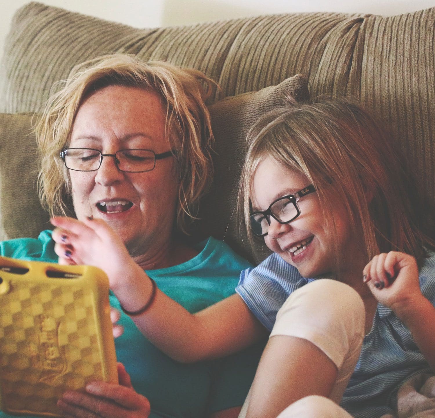 grandmother and grand-daughter play on tablet